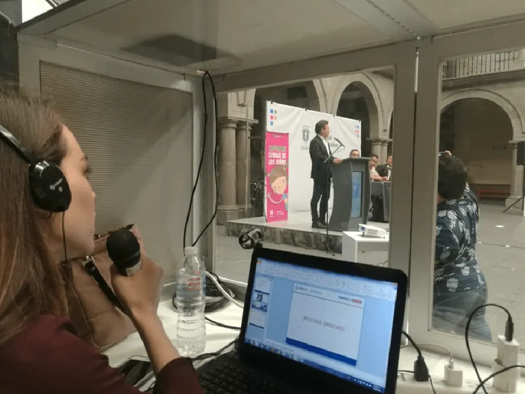 Intérprete de Connectional en cabina con audífonos durante un evento gubernamental
